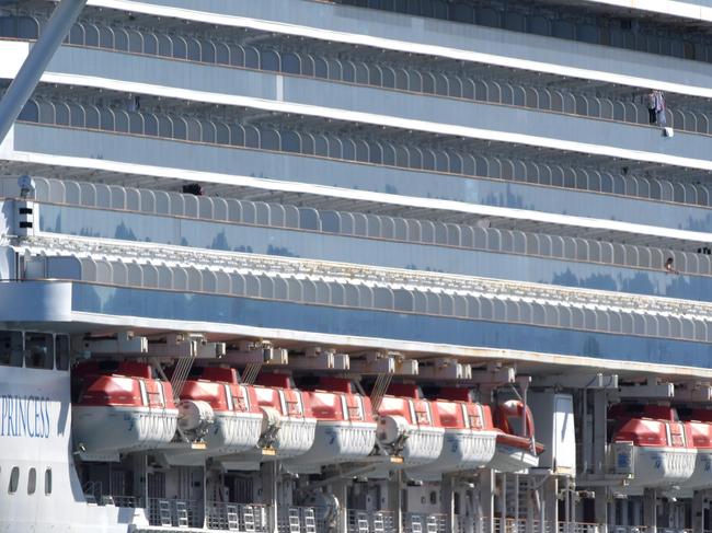 Clothes hang off the disease-stricken Ruby Princess before crew were taken off the ship at Port Kembla to fly back to their home countries on Tuesday.