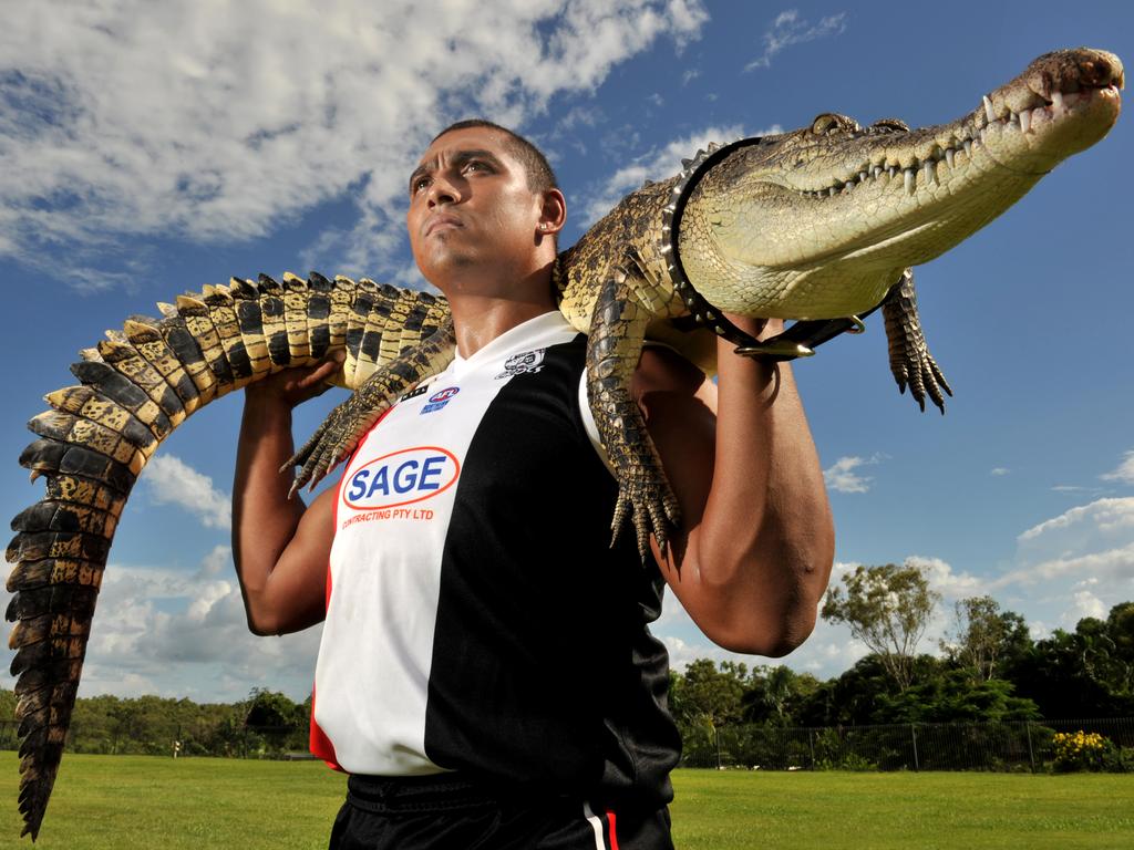 Damian Cupido carries a crocodile on his shoulders for a photo shoot during his time as a prodigious goal-kicker at the Southern District Crocs.