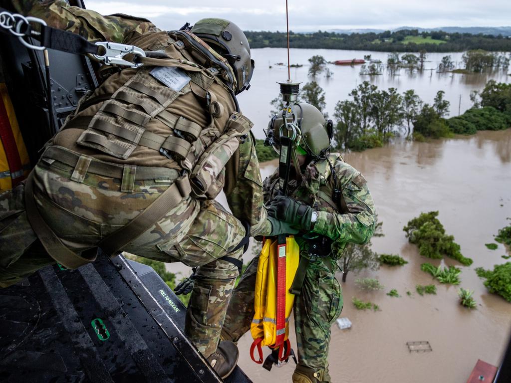 Australian Army aircrewman Warrant Officer Class Two Benjamin Dwyer from the School of Army Aviation prepares to conduct a rescue by winch of a community member from an MRH-90 Taipan, over Lismore, NSW during Operation Flood Assist 2022. Picture: Defence