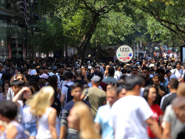 Shoppers walk the streets during the Boxing Day sales in the Sydney CBD last year. This year shoppers are being told to buy online or locally and to avoid the CBD. Picture: Steven Saphore