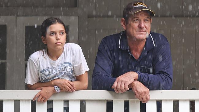 Neighbours Ross Bennett and Annabella Giorgas 11 watch on  in Hermit Park as Townsville residents endure another day of heavy rain and threats of catastrophic flooding. Pics Adam Head