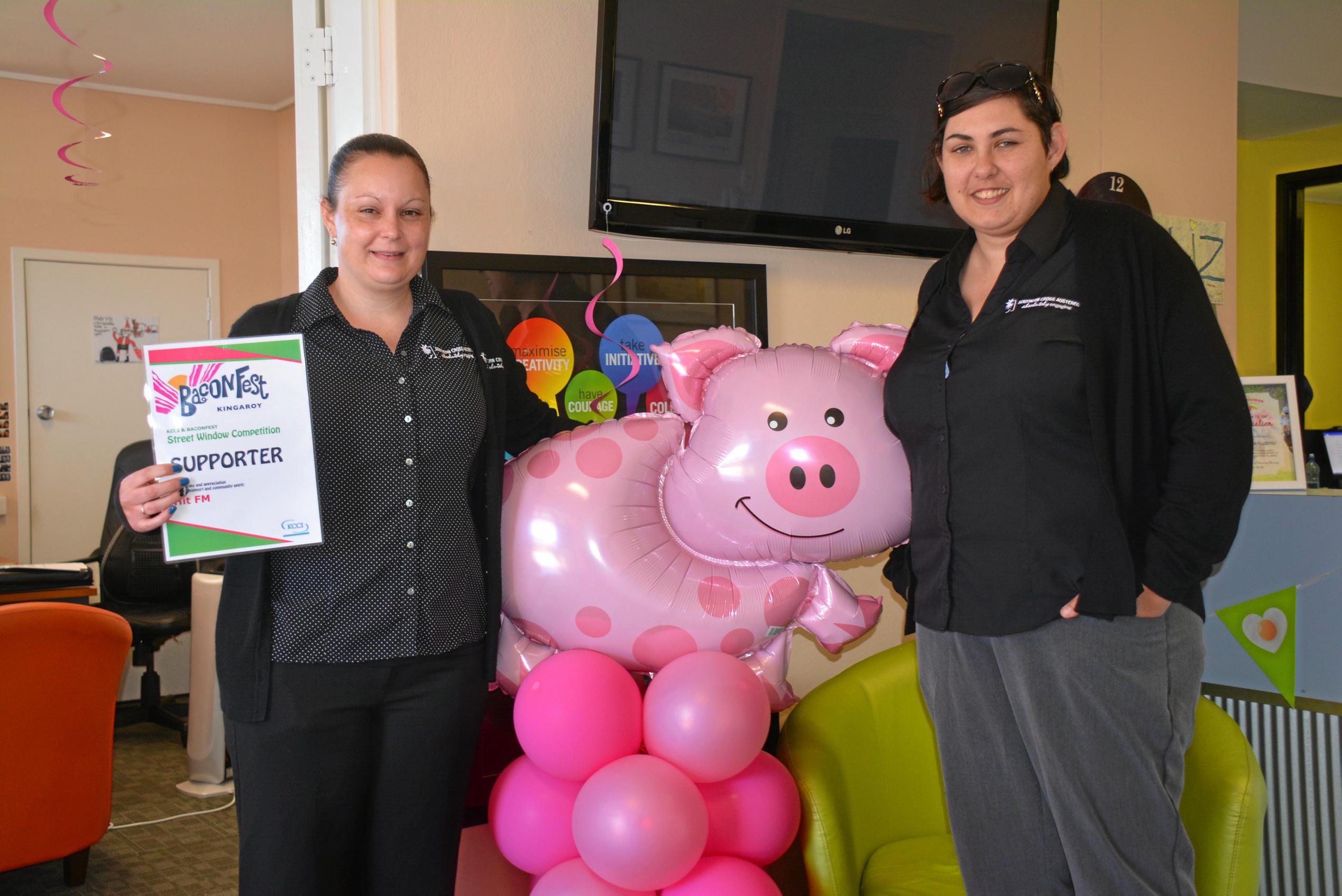 Hit 89.1 South Burnett station's Liz Kenny and Jamie Ferguson get into the BaconFest spirit with their shop displays. Picture: Jessica McGrath