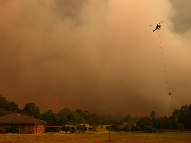 A firefighting helicopter fills up with water from a dam as the Grose Valley fire approaches Kurrajong Heights. Picture: AAP/Dan Himbrechts