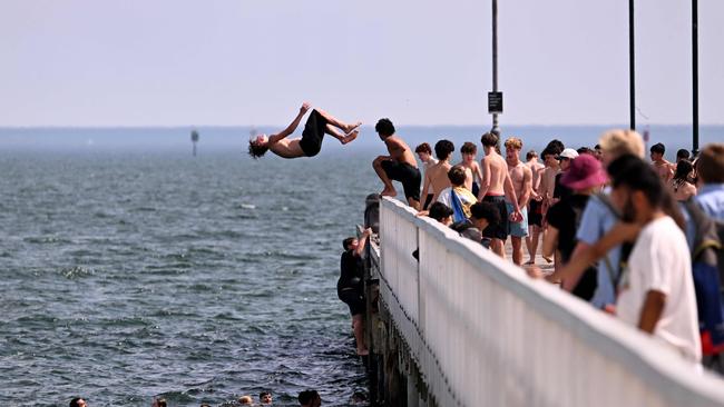 People jump off the Kerferd Road Pier as people cool off in heatwave conditions at Melbourne's Albert Park Beach on November 22. Picture: AFP