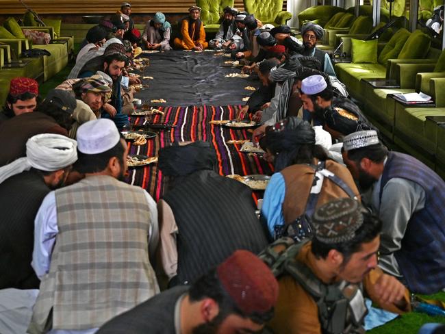 Taliban fighters eat their lunch inside the mansion. Picture: AFP