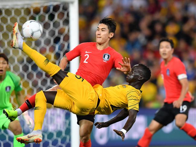 Awer Mabil (centre) of the Socceroos does an over head kick in the goal square as Lee Yong of Korea Republic  tries to stop him during the International friendly match between Australia and the Korea Republic at Suncorp Stadium, in Brisbane, Saturday, November 17, 2018. (AAP Image/Darren England) NO ARCHIVING, EDITORIAL USE ONLY