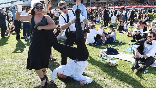 Racegoers horsing around on the field for Derby Day enjoyed the sunshine and the drinks. Picture: AAP.