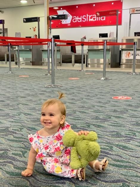 Mia Evans, 15 months, was reunited with Dino the green fluffy dinosaur at Townsville Airport after he was left on a Virgin Australia fight.