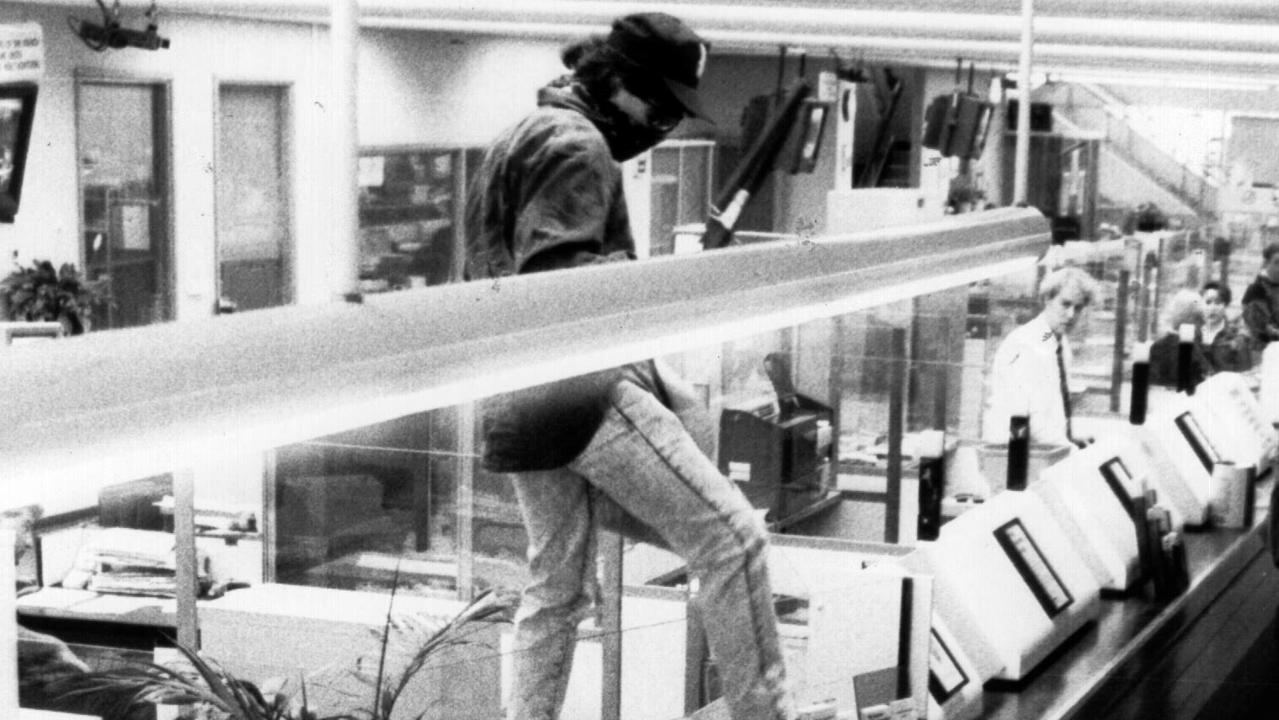 Binse mounting the counter during a holdup at Chatswood’s Commonwealth Bank in 1992. Picture: Supplied