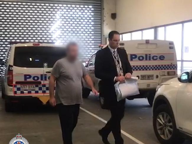 The man accused of serious child neglect being escorted to Tweed Heads Police Station in May, 2019.