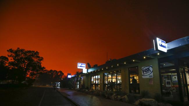 A background of fire in the main street outside the Mallacoota Hotel at 3.10pm on Saturday. Picture: David Caird