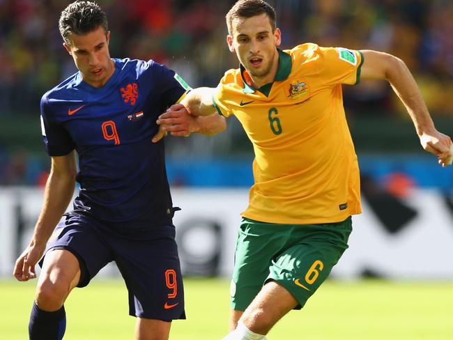 Matthew Spiranovic repels the challenge of Robin van Persie at the World Cup.