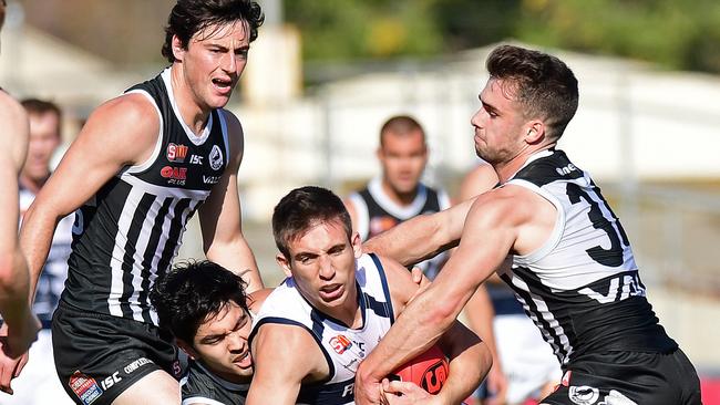 South's Joel Cross is tackled by Port's Simon Wong and Will Snelling. Picture: Tom Huntley