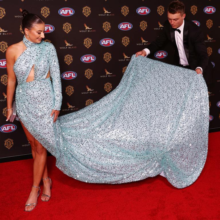 Carlton’s Patrick Cripps helped Monique Fontana with her giant train on the red carpet. Photo by Michael Klein