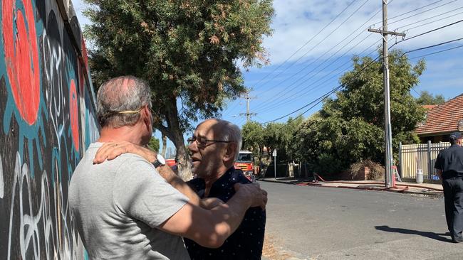 A friend comforts Alpha Trading owner Bader Rajab, pictured left, after a fire at his John St, Brunswick East warehouse. Picture: Kirra Grimes