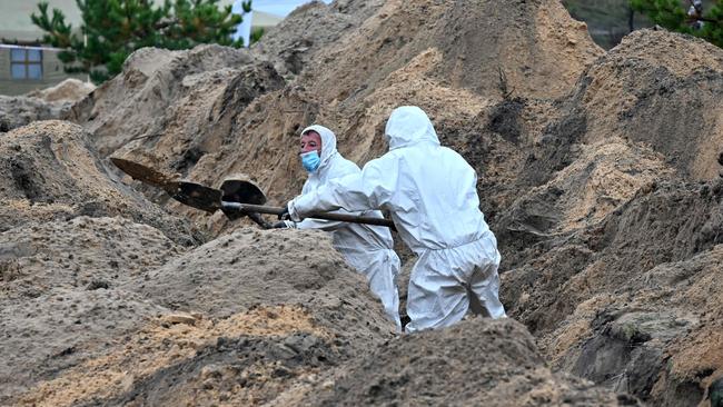 Forensic officers work to recover the bodies of 55 Ukrainian troops from a mass grave near the recaptured town of Lyman. Picture: AFP