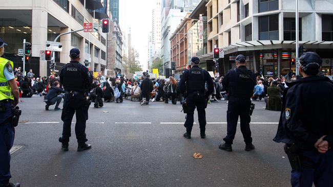 NSW Police officers stand guard at the edge of a 'Black Lives Matter' protest march in Sydney on Saturday. Picture: Getty