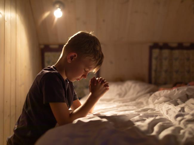 Little boy saying prayer before going to bed.