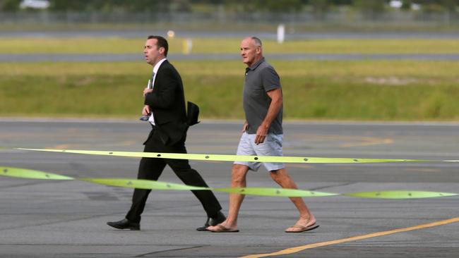 Chris Dawson is escorted by NSW Police to his flight to be extradited from Queensland to NSW to face charges of murder over the death of his wife Lyn. Picture: Lyndon Mechielsen