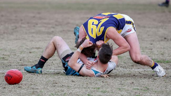 EDFL: Riley McLaughlin of Hillside and Rupertswood’s Mitchell Johnson carry on. Picture: George Salpigtidis