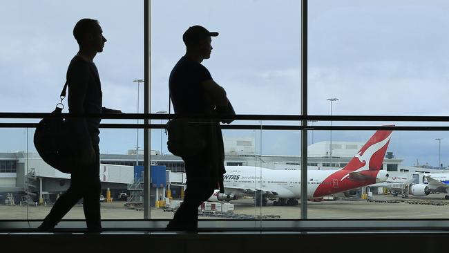 Passengers walk past a Qantas jet at the International terminal at Sydney Airport. Picture: Getty Images