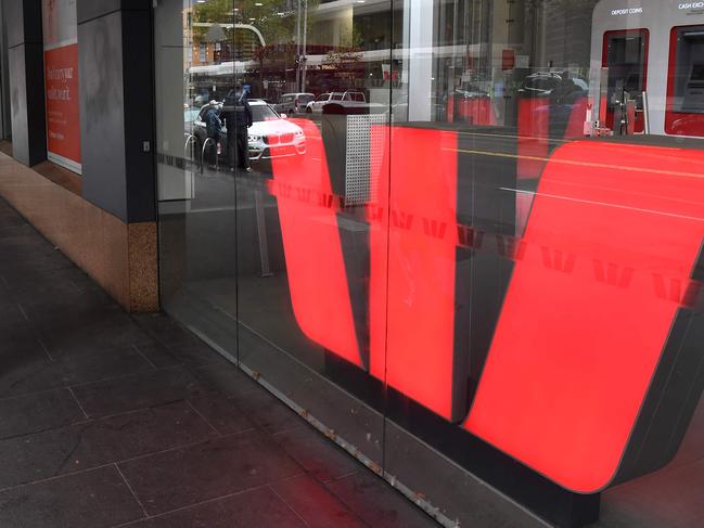 A man walks past a Westpac bank sign in Melbourne's central business district on May 4, 2020. - Westpac on May 4 announced its half-year net profit had fallen 62 percent, making it the latest Australian bank to see profits dive during the coronavirus crisis. (Photo by William WEST / AFP)