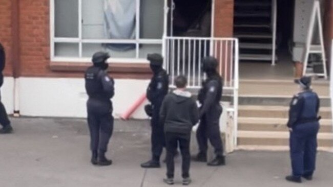 Picture taken of the police raid on Mumford's home in Caringbah in September 2021. The man pictured alongside police is another tenant of the building.