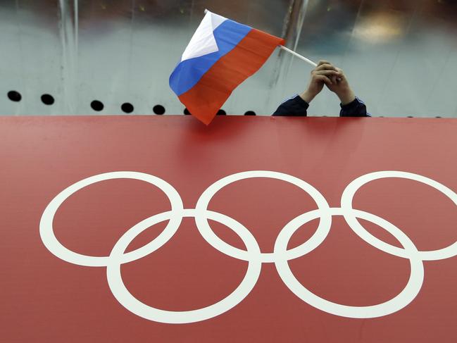 FILE - In this Feb. 18, 2014 file photo, a Russian skating fan holds the country's national flag over the Olympic rings before the start of the men's 10,000-meter speedskating race at Adler Arena Skating Center during the 2014 Winter Olympics in Sochi, Russia. The credibility of the fight against doping in sports will be at stake Friday, June 17, 2016 when track and field's world governing body decides whether to uphold or lift its ban on Russian athletes ahead of the Rio de Janeiro Olympics. Sports geopolitics â€” and the key issue of individual justice vs. collective punishment â€” frame the debate heading into the meeting of IAAF leaders in Vienna. (AP Photo/David J. Phillip, file)