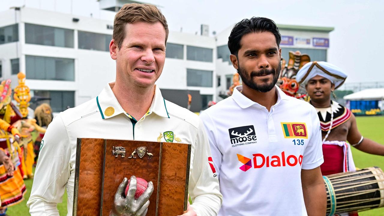 Skipper Smith carries the Warne-Muralitharan trophy with Sri Lankan counterpart Dhananjaya de Silva. (Photo by Ishara S. KODIKARA / AFP)