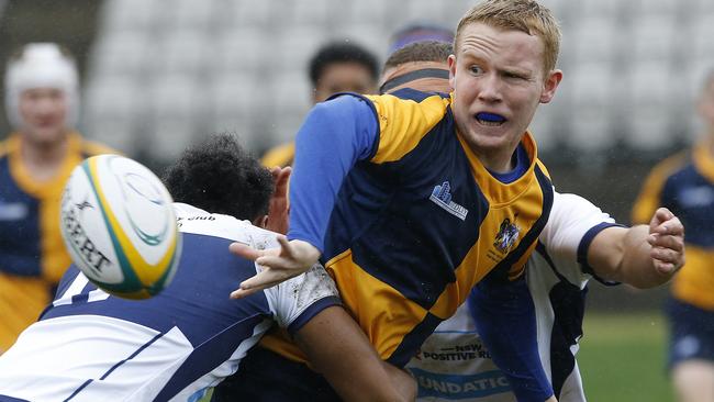 ACT's Andrew McFarlane gets the ball away against NSW Juniors.