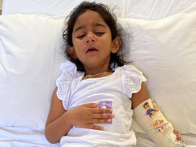 , The youngest daughter of the ‘Biloela family’, Tharnicaa, is currently being medically evacuated to Perth after being hospitalised on Christmas Island with a suspected blood infection (septicaemia)., Tharnicaa in hospital on Christmas Island on Sunday 6 June. Kopika (her sister) comforts her with a kiss. Supplied: Change.org