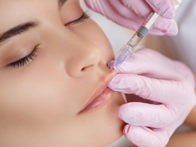 The doctor cosmetologist makes Lip augmentation procedure of a beautiful woman in a beauty salon.Cosmetology skin care.