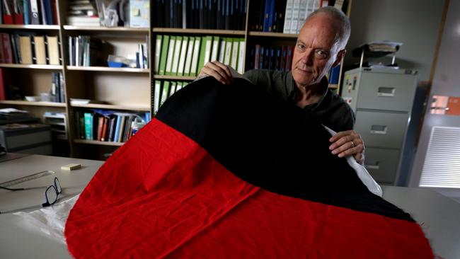 Philip Jones with a remnant of the flag at the SA Museum. Picture: Kelly Barnes