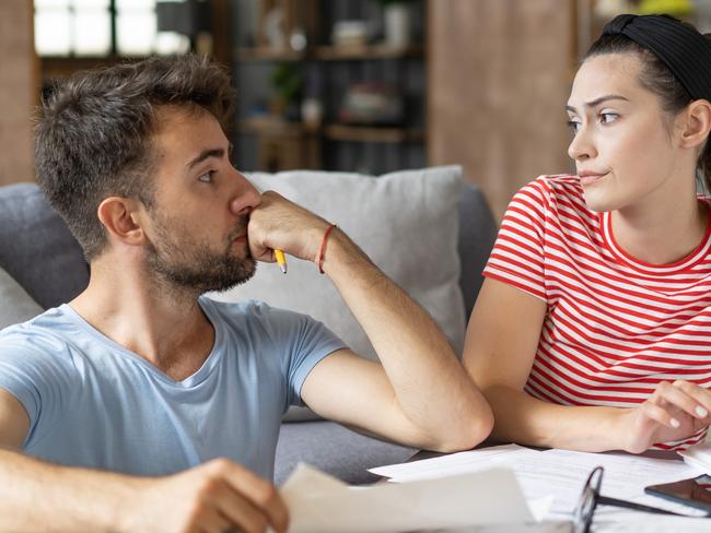 Frustrated concerned young couple calculating overspend budget, doing paperwork job at laptop, talking about financial problems, insurance, mortgage, fees, loan conditions, bankruptcy, economic inflation; money budgeting stress banking generic