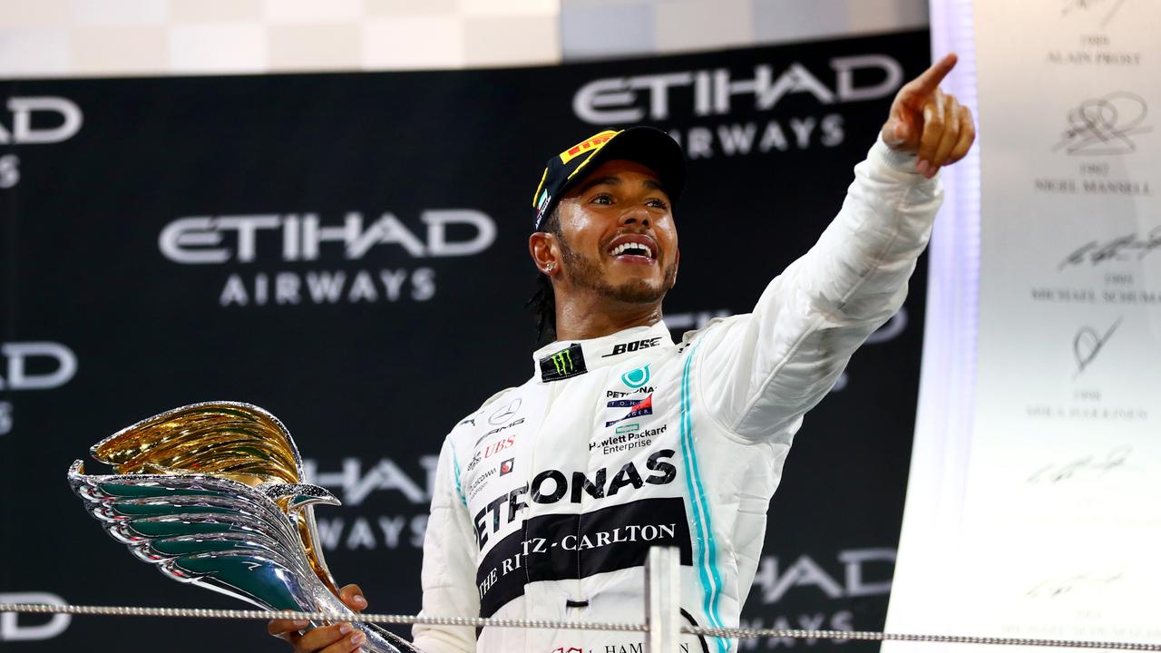 Race winner Lewis Hamilton celebrates on the podium.
