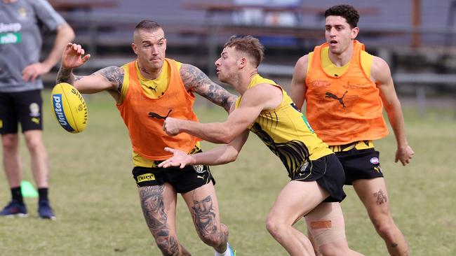 Richmond’s Jake Aarts handballs clear of Dustin Martin, as the club trains at Broadbeach Football Club on the Gold Coast. Picture: Michael Klein