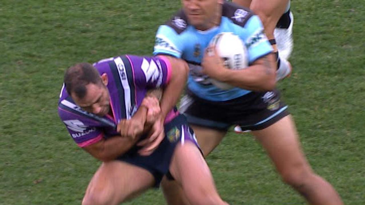 Cameron Smith uses a chicken wing tackle on Sosaia Feki.