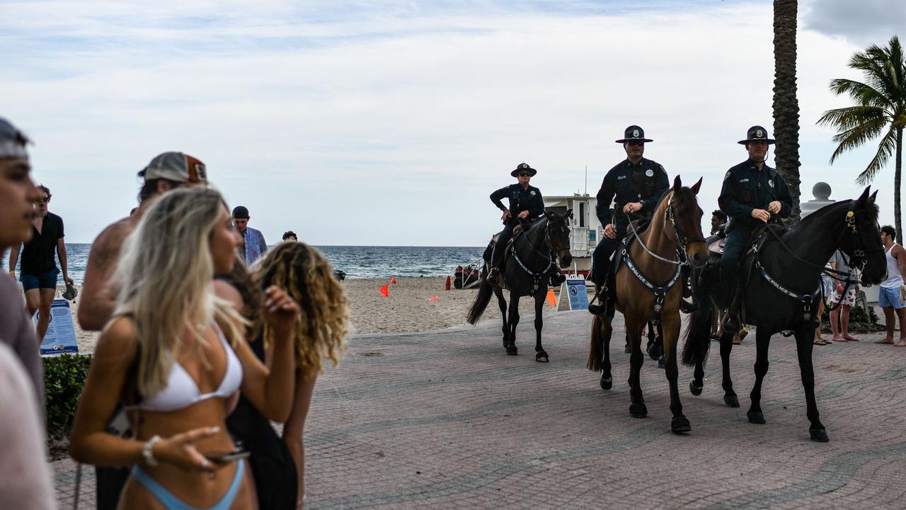 Police patrol the beach in Florida as Spring Break partygoers watch on. Picture: Chandan Khanna/AFP
