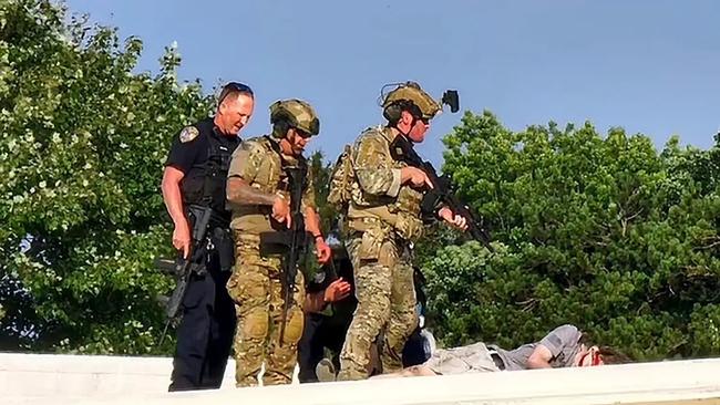 In a photo obtained by the New York Post, police stand over the body of the alleged shooter responsible for the attempted assassination of former president Donald Trump, in Butler, PA on July 13, 2024.