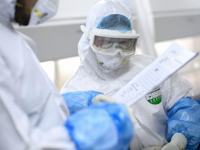 Laboratory technicians work on samples from people to be tested for coronavirus at "Fire Eye" laboratory in Wuhan. Picture: AFP