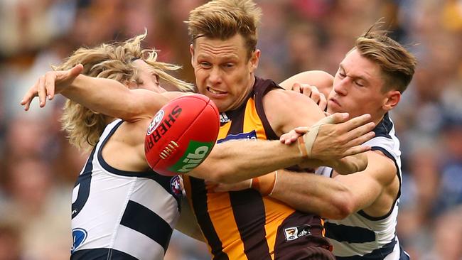 Sam Mitchell gets swamped by two Geelong defenders.