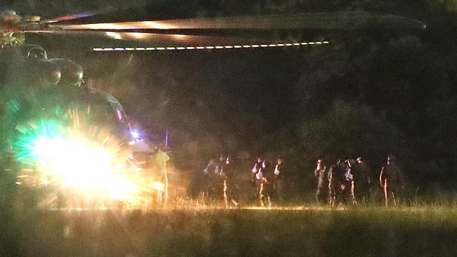 Thai medics and police officers evacuate the first two children with a helicopter after rescued from Tham Luang cave before heading to hospital, at a helicopter pad in Chiang Rai province. Picture: EPA