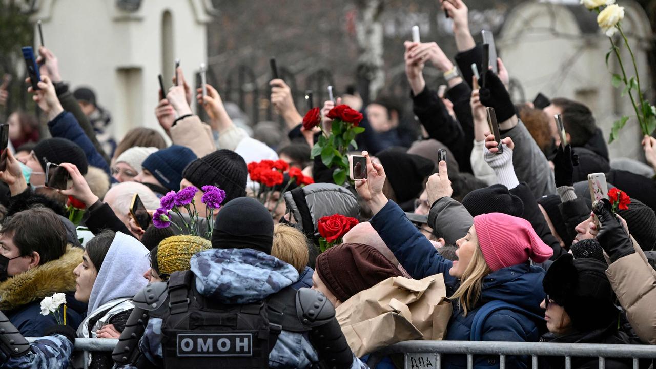 Mourners react as the hearse carrying the coffin of late Russian opposition leader Alexei Navalny leaves the Mother of God Quench My Sorrows church towards the Borisovo cemetery for Navalny's burial, in Moscow's district of Maryino on March 1, 2024. (Photo by Alexander NEMENOV / AFP)