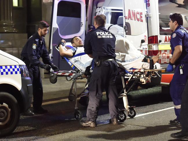 An extremely aggresive man, thought to be under the influence of methamphetamine is finally restrained to a stretcher after a group of up to 10 NSW Police and ambulance officers struggled to subdue him. Picture: Gordon McComiskie