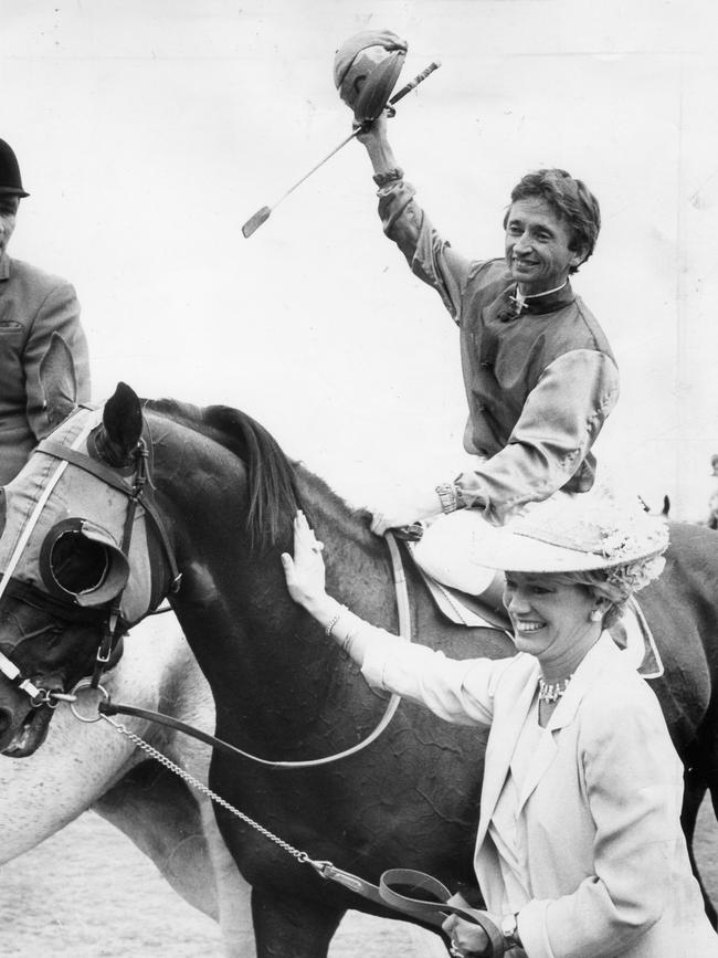 John Letts, after winning the 1980 Melbourne Cup aboard Beldale Ball, is led back to scale by owner Susan Sangster at Flemington Racecourse.