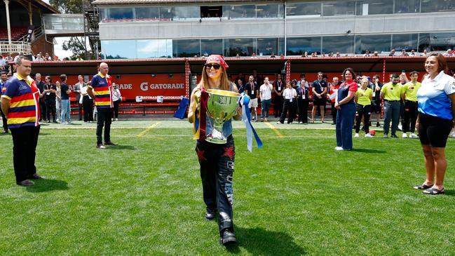 MG Flip is seen with the premiership cup during the 2023 AFLW Grand Final match. Graham McBride is second from left along with close family friend Alex Tigani (left). Picture: Dylan Burns/AFL Photos via Getty Images