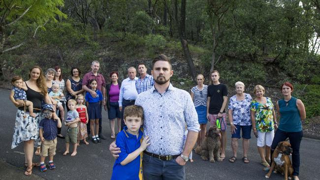 Nathan residents Josh Wood with his son Jack and neighbours, Member for Toohey Peter Russo, Councillor Steve Griffiths in front of Toohey Forest. Picture: AAP/Renae Droop