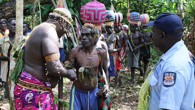 A referendum returning officer, left, leads an Upe man to men-only polling station in in Teau, Bougainville, Papua New Guinea. Picture: AP