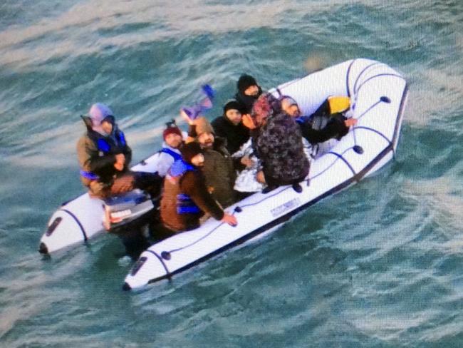 This image provided by the Marine Nationale (French Navy) shows migrants aboard a rubber boat after being intercepted by French authorities, off the port of Calais, northern France, Tuesday, Dec. 25, 2018. French authorities have rescued eight migrants, including two children, whose engine failed as they tried to sneak across the English Channel to Britain. (Marine Nationale via AP)