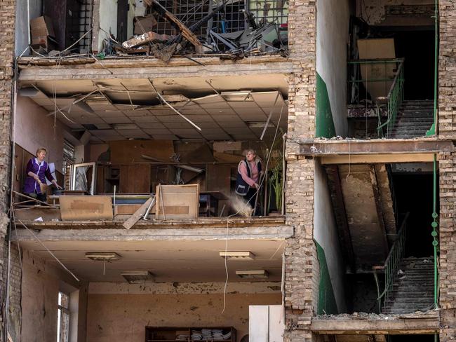 Women clean in a building with a collapsed facade at the Vizar military-industrial complex, after the site was hit by overnight Russian strikes, in Vyshneve, southwestern suburbs of Kyiv. Picture: AFP